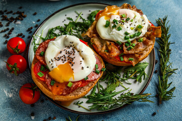 Plate with tasty eggs Benedict on blue background