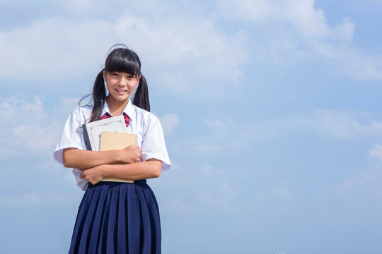 海辺でノートを抱く中学生