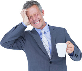 Businessman suffering from headache while holding coffee cup