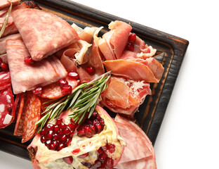 Wooden board with assortment of tasty deli meats isolated on white background, closeup
