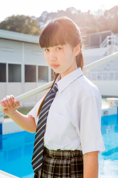プール掃除をする女子中学生
