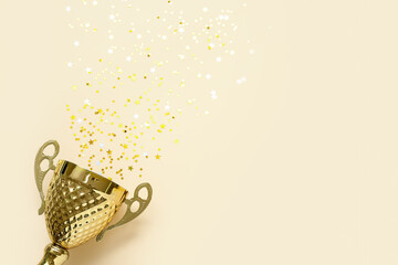 Gold cup with stars on beige background