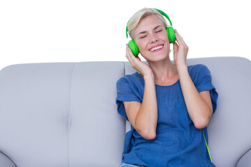 Happy woman listening music on the couch