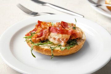 Tasty bacon bruschetta with arugula on white table