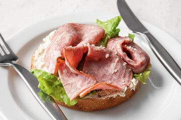 Tasty ham bruschetta with lettuce on white table