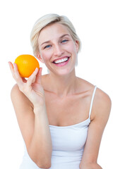 Happy woman holding an orange smiling at camera 