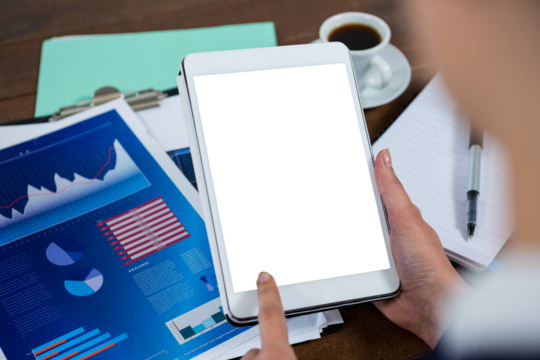 Businesswoman using digital tablet with graph chart on table