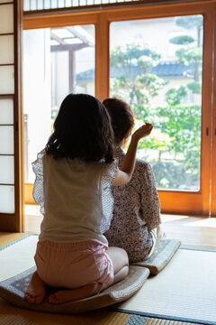 祖母の肩叩きをする孫