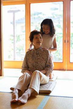 祖母の肩叩きをする孫