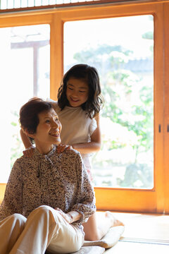 祖母の肩叩きをする孫