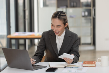 Happy excited young successful asian business woman working at the table in office, Businesswoman and finance marketing.