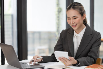 Happy excited young successful asian business woman working at the table in office, Businesswoman and finance marketing.