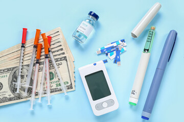 Insulin with glucometer, lancet pens, syringes and money on blue background. Expensive medicine concept