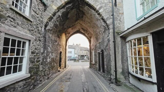 Editorial footage of the Cumbrian Village of Cartmel in the English Lake District. Showing traffic and tourists walking and shopping