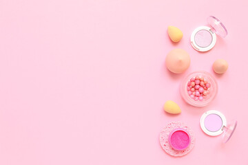 Decorative cosmetics with makeup sponges on pink background