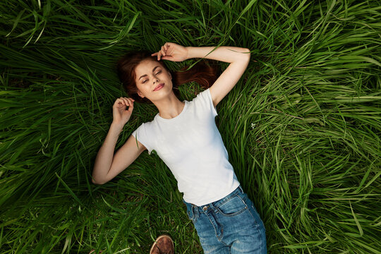 a woman lies in the tall grass with her eyes closed