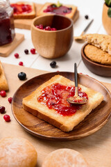 Plate of tasty toast with jam on table