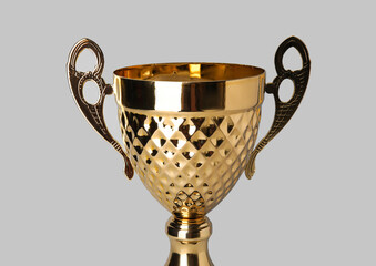Gold cup on grey background, closeup