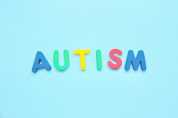 Word AUTISM on blue background
