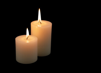Fototapeta na wymiar Two burning candles isolated on black background. Copy space for text.