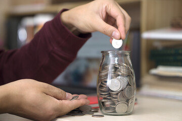 Fototapeta na wymiar Put coins in glass bottles to save money