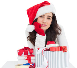Unsure brunette in santa hat packing gifts