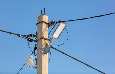 An electric lantern on a pole against a blue sky.