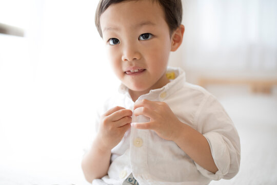 洋服のボタンをとめている男の子