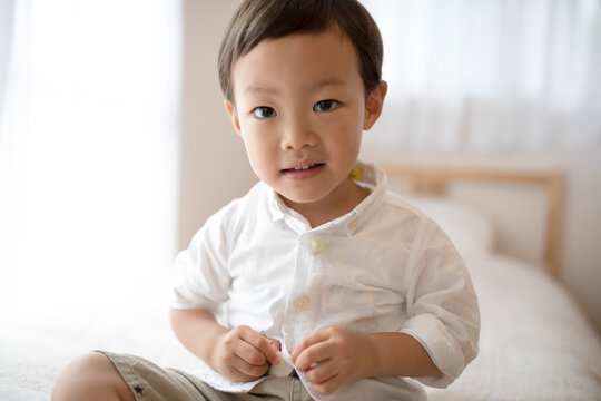 洋服のボタンをとめている男の子