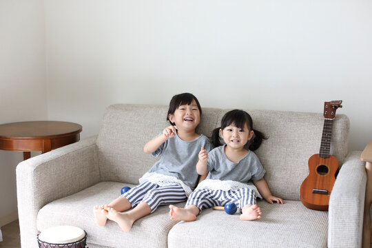 ソファーに座る小さな姉妹