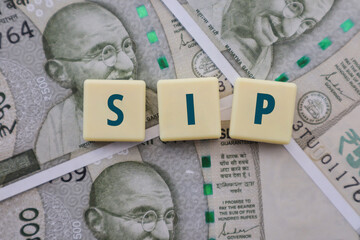 Mutual Fund SIP written on Tiles on Indian Rupee Notes - Systematic Investment Plan