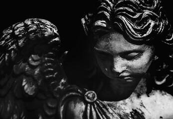 Death. Portrait of sad angel as symbol of pain, fear and end of life. Ancient stone statue. Black...