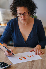 woman making hand calligraphy, lettering with the word lifestyle
