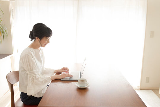 リビングルームでノートパソコンを使う女性