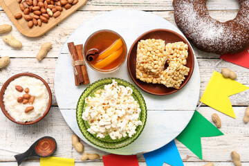 Traditional food with flags for Festa Junina (June Festival) on white wooden background