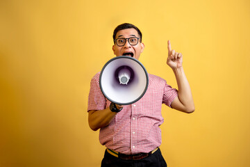 Man with eyeglasses and a shirt talking on a megaphone