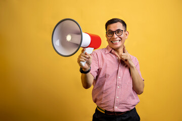 Man with eyeglasses and a shirt talking on a megaphone