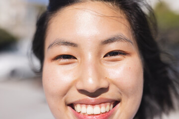 Portrait of happy asian woman looking at camera and smiling at beach