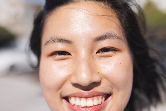 Portrait Of Happy Asian Woman Looking At Camera And Smiling At Beach