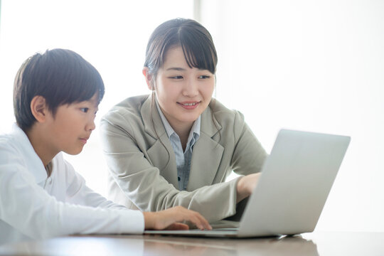 先生にプログラミングの勉強を教わる小学生  AR