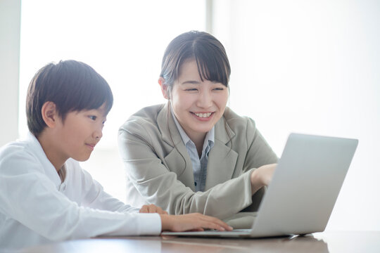 先生にプログラミングの勉強を教わる小学生  AR