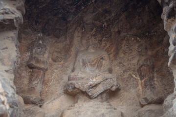 Carved Buddha Limestone at Longmen Grottoes or Caves (Dragon gate Grottoes), The World Heritage Site in Luoyang, Henan province, China. Selective focus