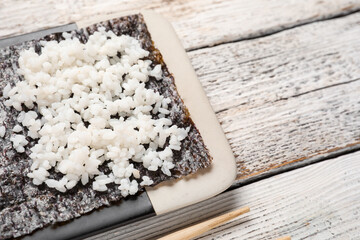 Nori with rice on light wooden background, closeup