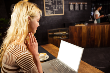 Woman looking at laptop screen in coffee shop