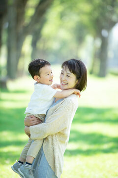 ポプラ並木で子供を抱き微笑む母親