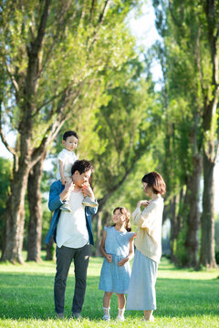 ポプラ並木で談笑をする家族