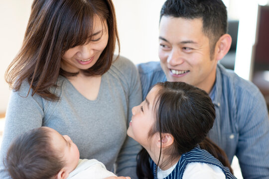 赤ちゃんを囲み談笑をする家族