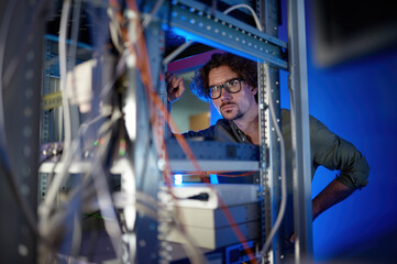 Man technician repairing supercomputer system unit, changing parts