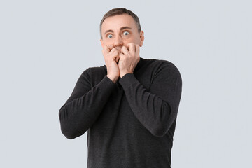 Scared mature man on light background