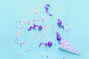 Obraz na płótnie Canvas Party cone with serpentine and confetti on blue background